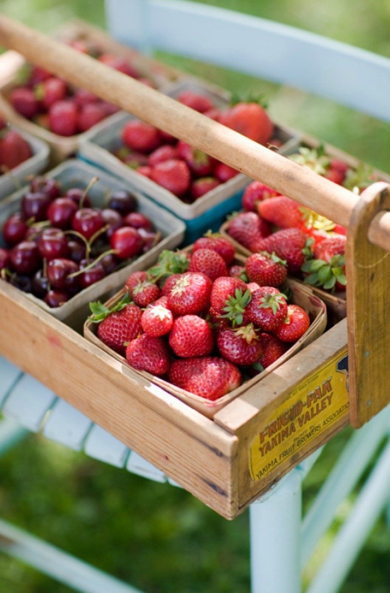 Sommerliche Gartendekoration für ein Fest im Freien mit frischen Erdbeeren, Kirschen und Pfirsisch